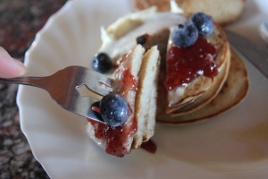 Buckwheat and coconut flour pancakes, topped with coconut cream, strawberry compote, and  fresh blueberries! 